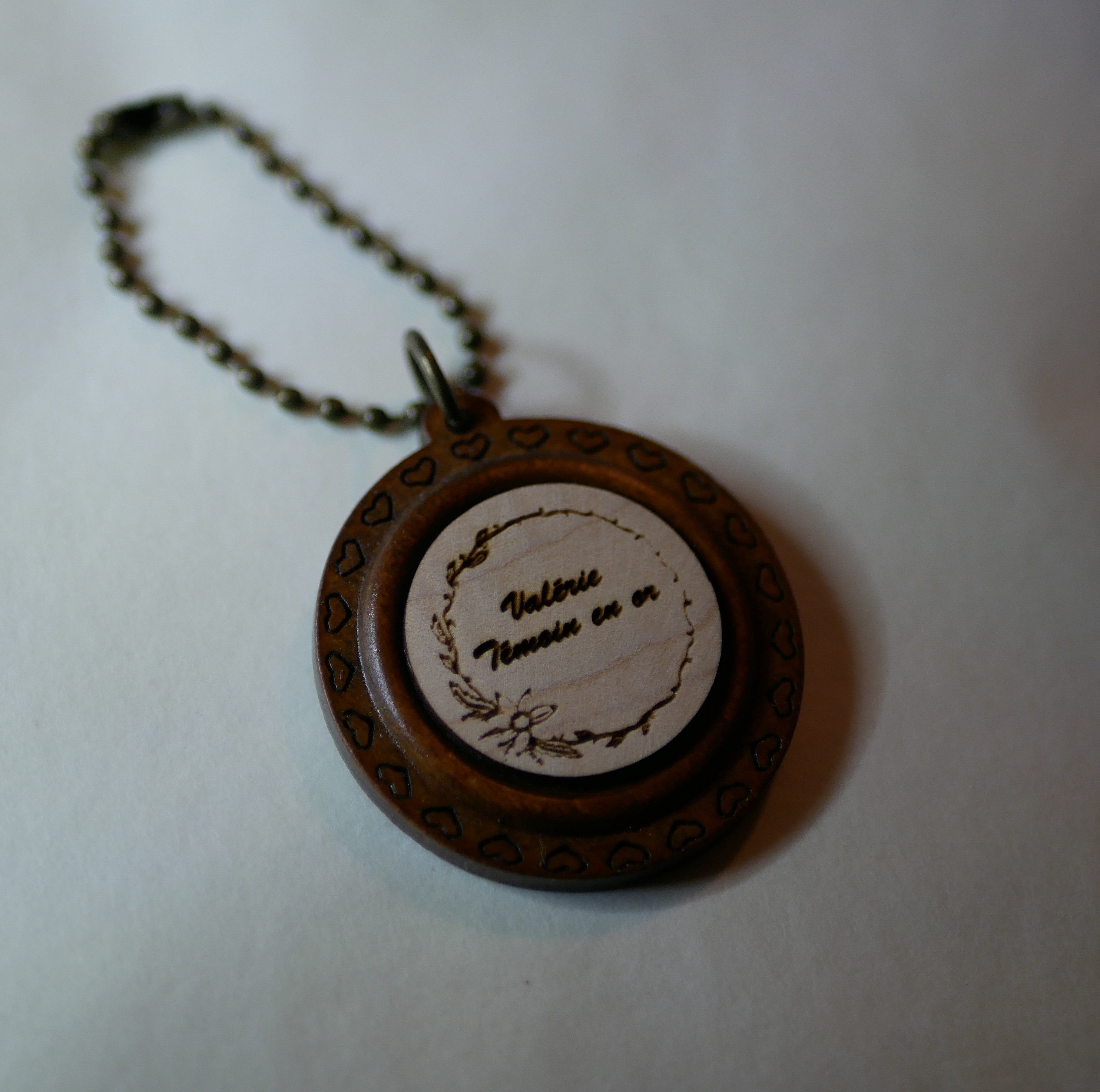 Porte-clé cabochon en bois gravé avec encadrement rond.